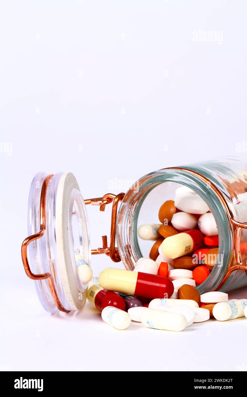 Glass jar filled with prescription drugs spilling out Stock Photo