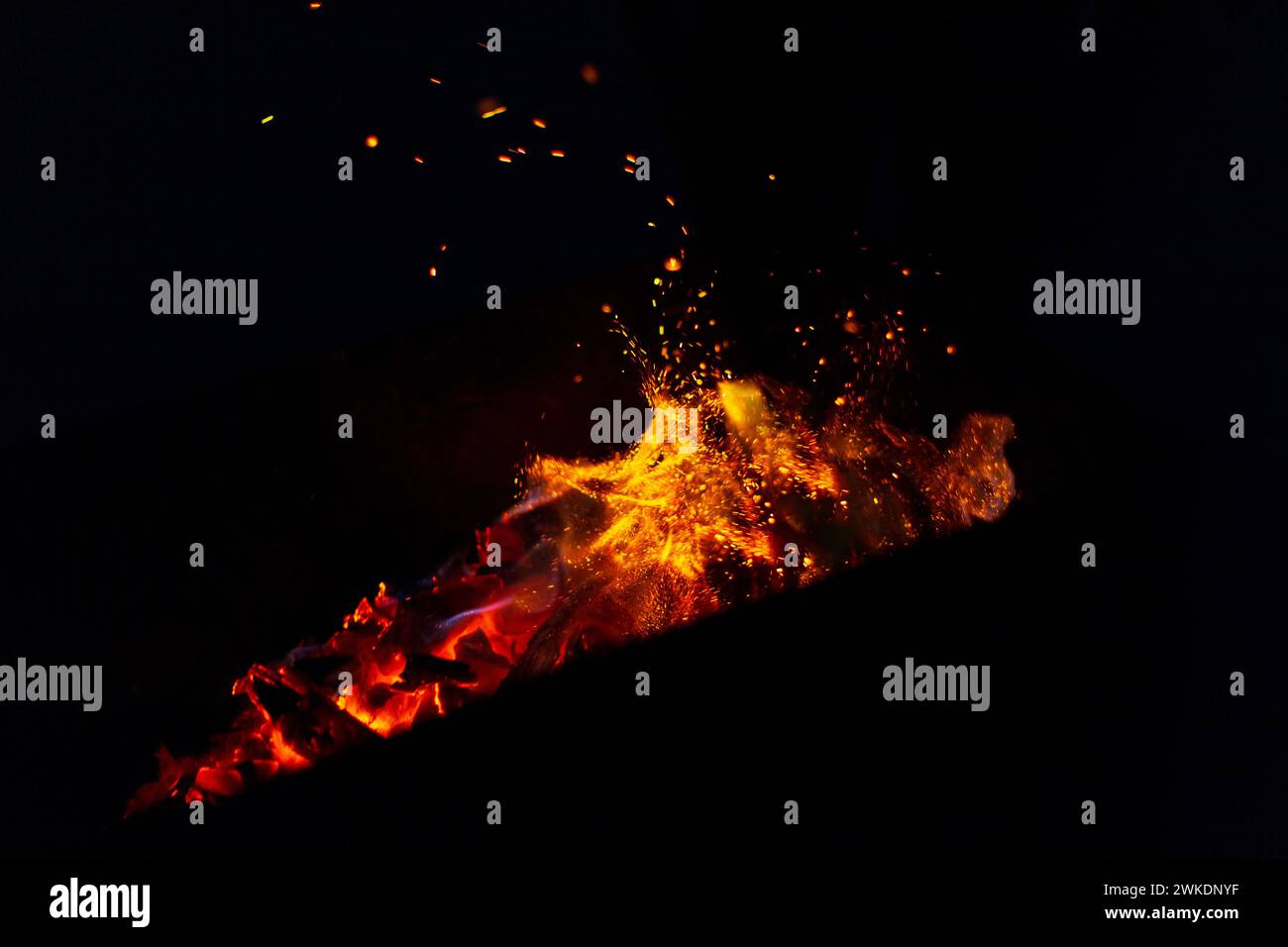 beautiful fire burns with sparks in the night. Bonfire on a black background Stock Photo