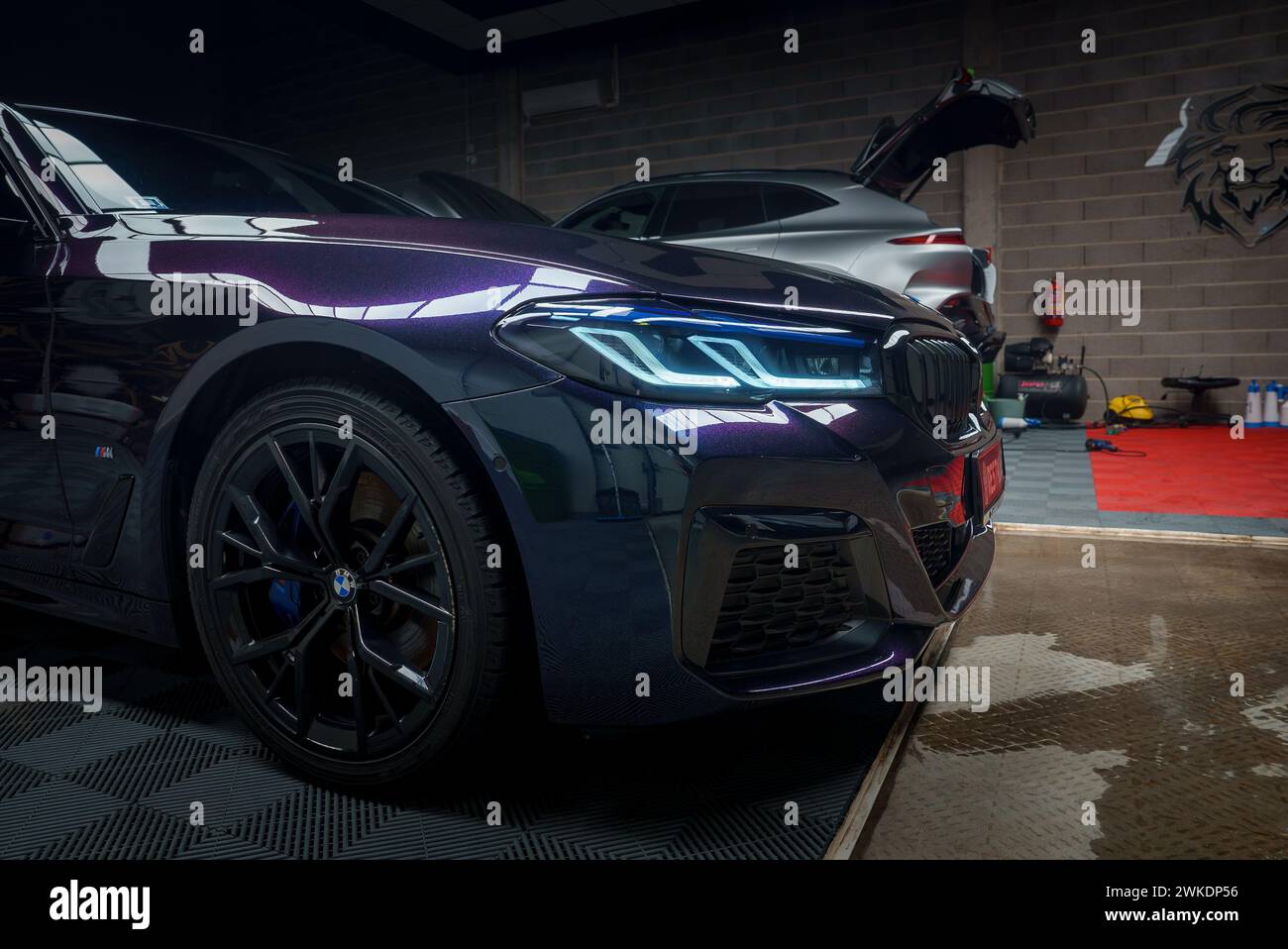 CloseUp View Sleek BMW Car in Tuning Garage, Blue Headlights Shining ...