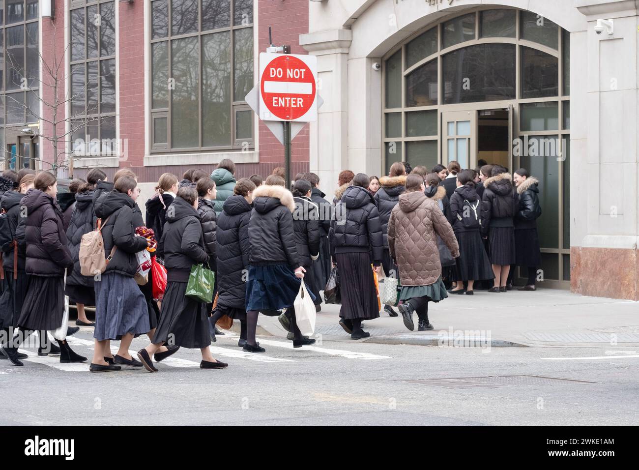 A very large group of modestly dressed orthodox Jewish girls go to school on a winter Sunday morning Stock Photo