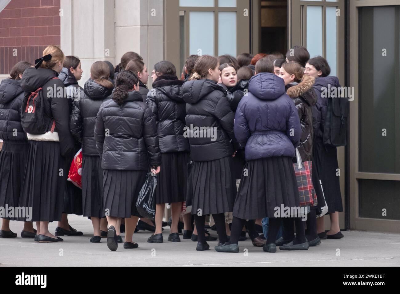 A large group of modestly dressed orthodox Jewish girls go to school on a winter Sunday morning minutes before classes started. Stock Photo