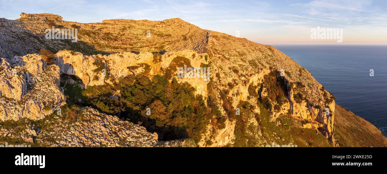 ascent to Llanero arches (eyes of the devil), Pico Candina, Sonabia, Castro Urdiales, Cantabria, Spain. Stock Photo