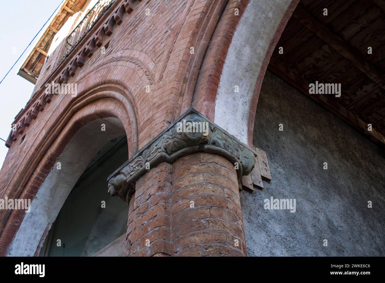 Details of the pointed arches of the Casa di Porta Ferrata in Avigliana, medieval village in Piedmont, with capitals sculpted with fantastic figures. Stock Photo