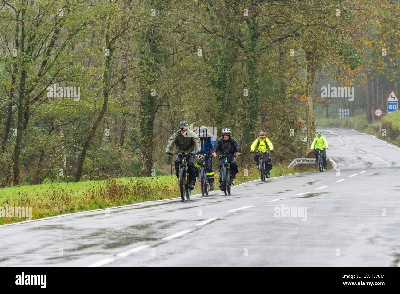 cyclists in the rain, Segura, Idiazabal, Gipuzkoa, Basque country, Spain. Stock Photo