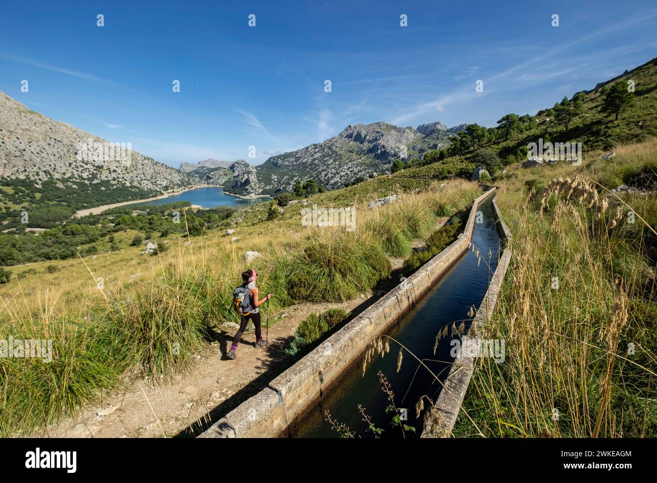 escursionista andando junto a la canal de transvase del Gorg Blau - Cúber, Escorca, Paraje natural de la Serra de Tramuntana, Mallorca, balearic islands, Spain. Stock Photo