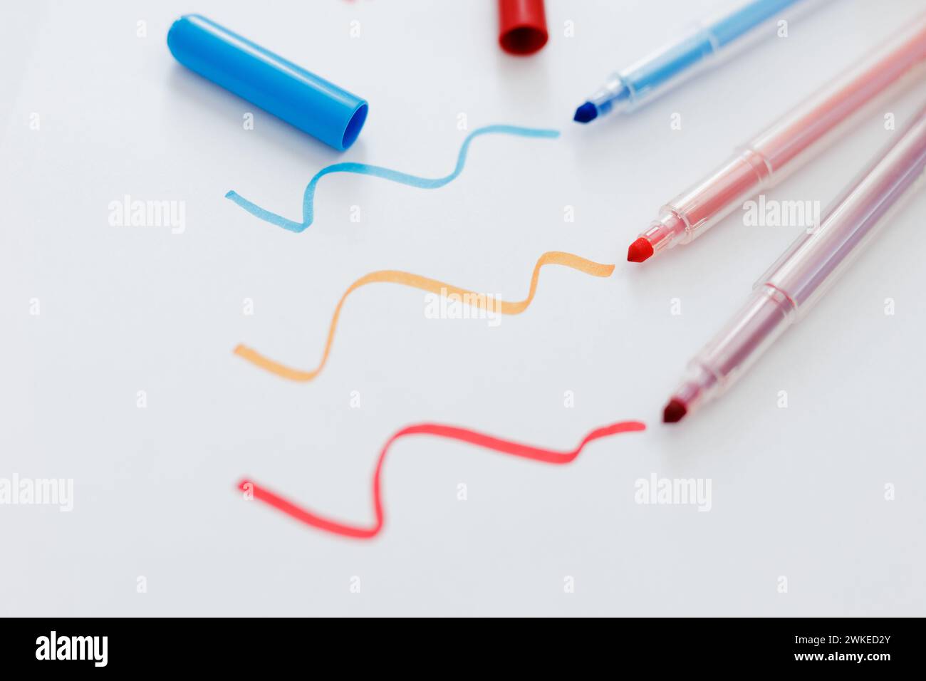 close up of colorful markers and hand drawn lines on white paper ...