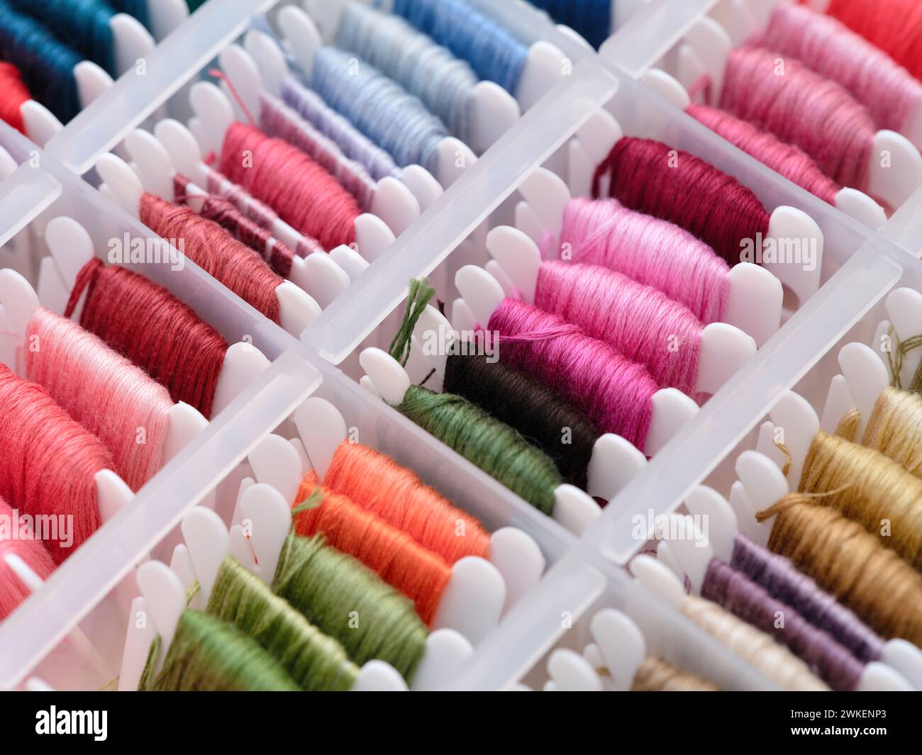 Bobbins with different colour embroidery threads in a plastic sorting ...