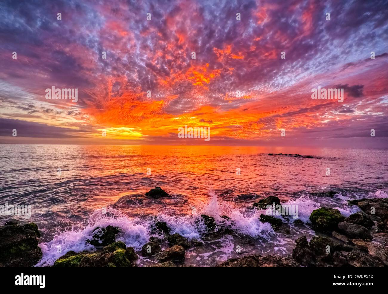 Brilliant red clouds in the sky at sunset over the Gulf of Mexico at Caspersen Baech in Venice Florida USA Stock Photo