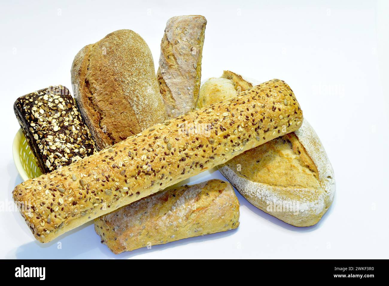 Bread, different in shape, taste and preparation technology, lies on a white table. Stock Photo