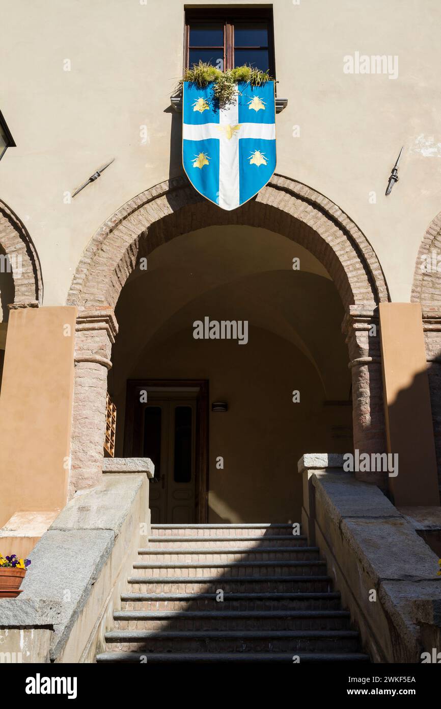 Flag of the municipality of Avigliana with its coat of arms in the courtyard of the stronghold of the Beato Umberto II. Stock Photo
