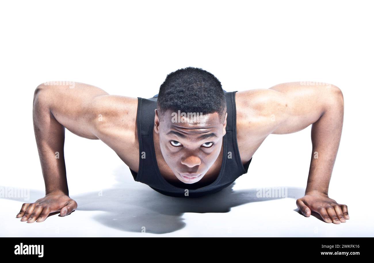 An athletic young black British man performing a push up. Stock Photo