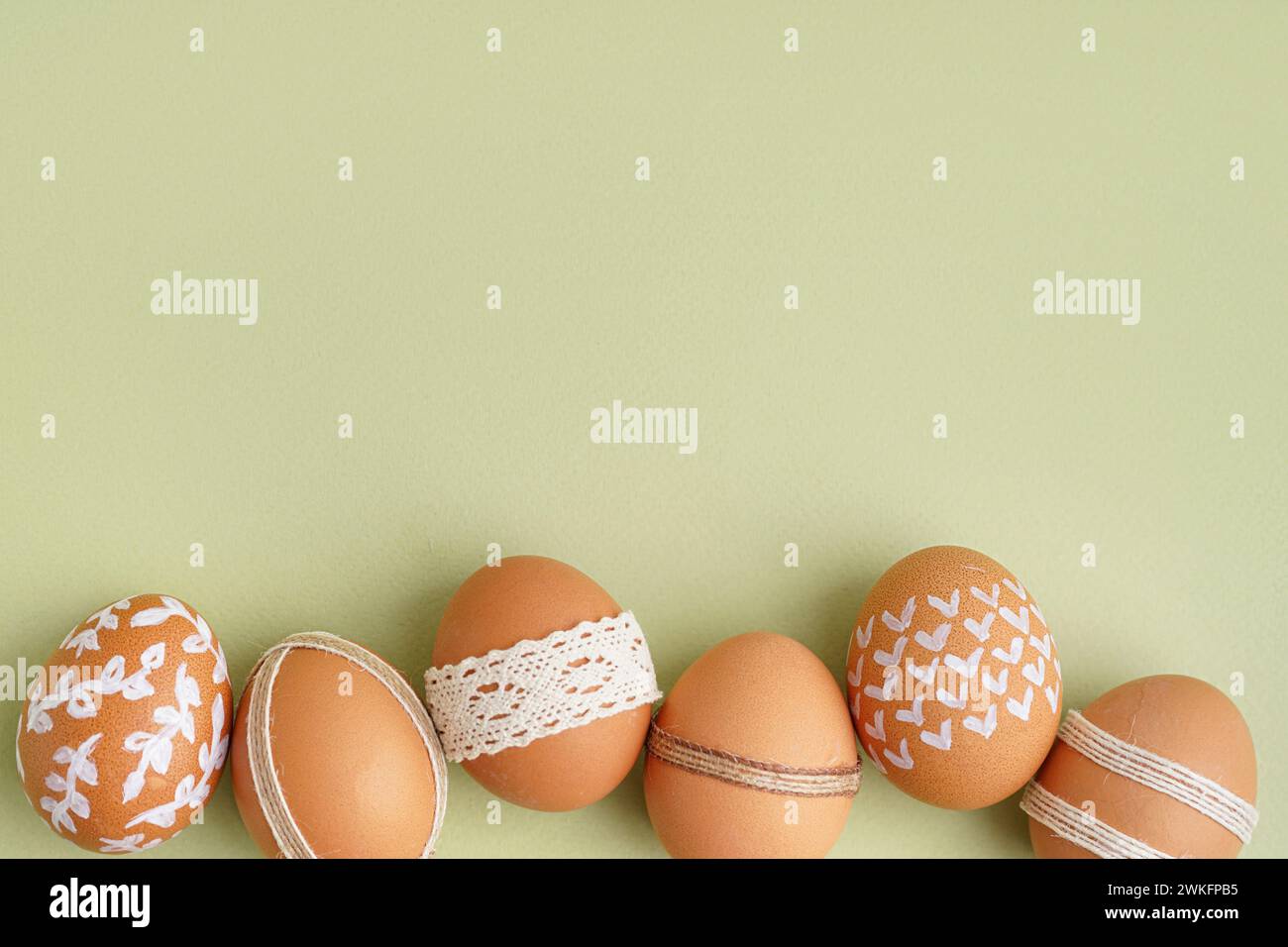 Composition with decorated Easter eggs on green background Stock Photo
