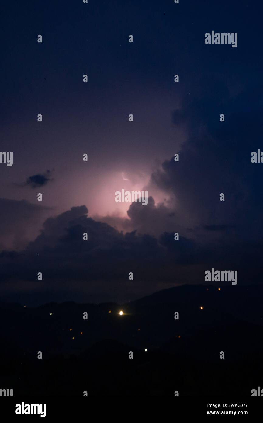 An evening thunderstorm with lightning in the Carpathian mountains, the village of Dzembronya. Dramatic clouds during a thunderstorm pierce the light Stock Photo