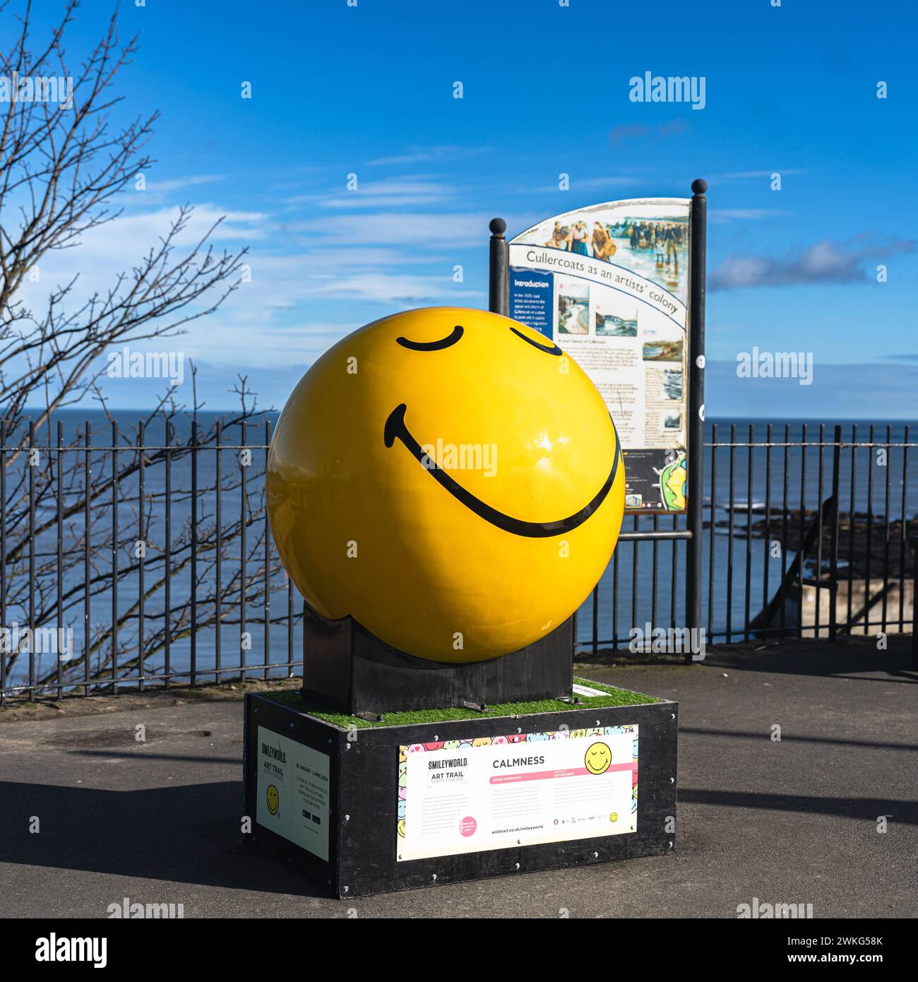 Yellow smiley face sculpture on a plinth, in Cullercoats, North Tyneside Stock Photo