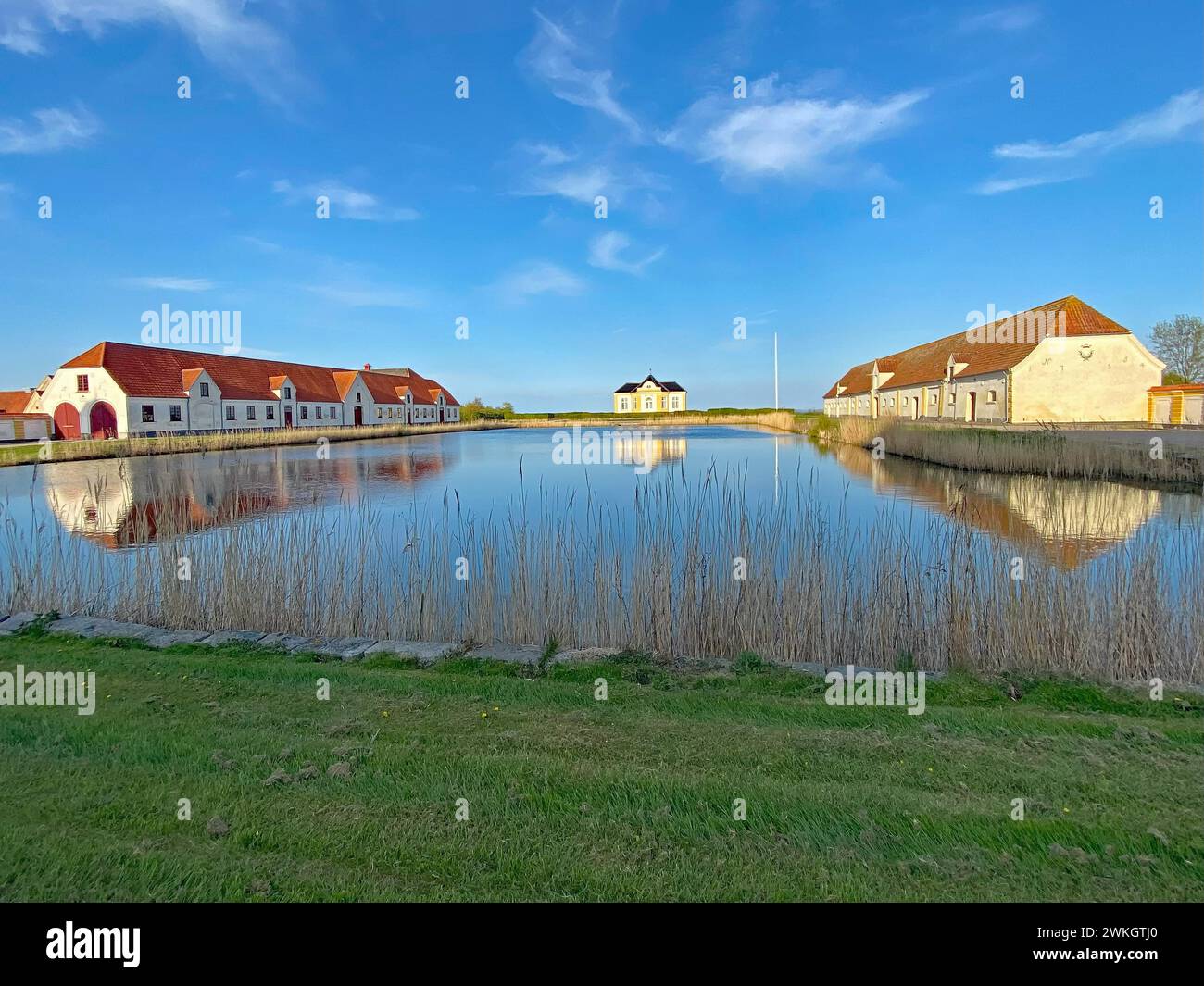 Large houses and the teahouse at Valdemars Slot are reflected in the calm water, Valdemars Slot, Manor Route, Tasinge, Denmark Stock Photo