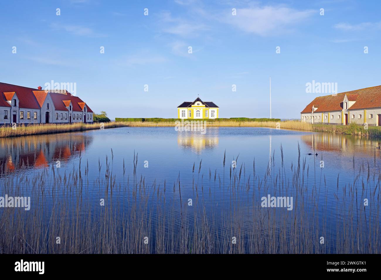 Large houses and the teahouse at Valdemars Slot are reflected in the calm water, Valdemars Slot, Manor Route, Tasinge, Denmark Stock Photo