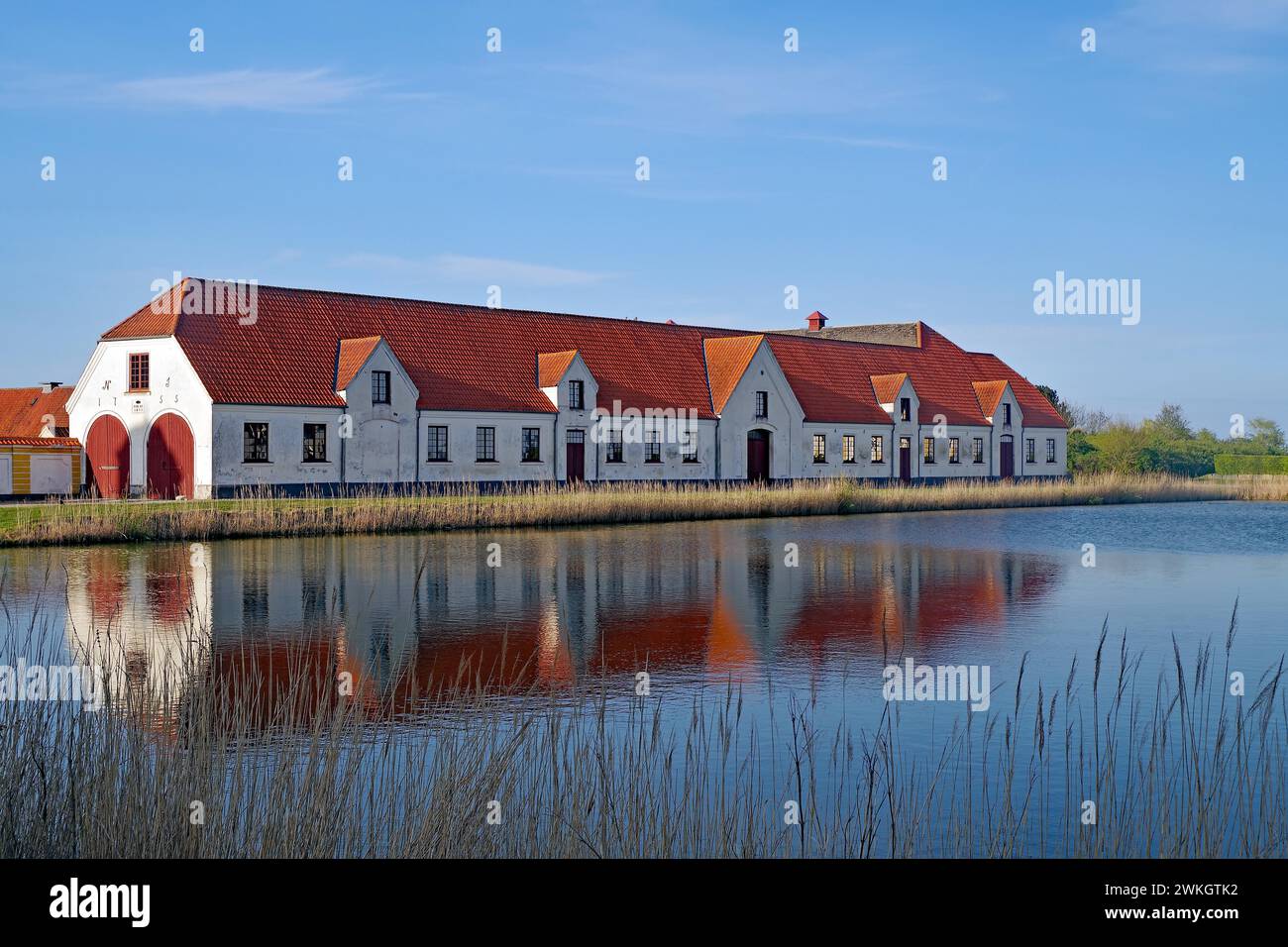 Large houses and the teahouse at Valdemars Slot are reflected in the calm water, Valdemars Slot, Manor Route, Tasinge, Denmark Stock Photo