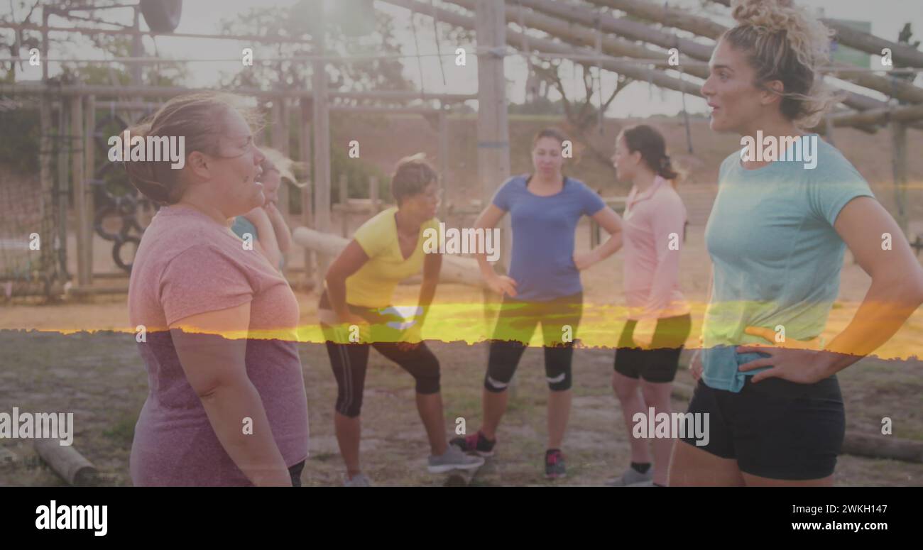 Image of sunset over diverse women at obstacle course talking Stock Photo