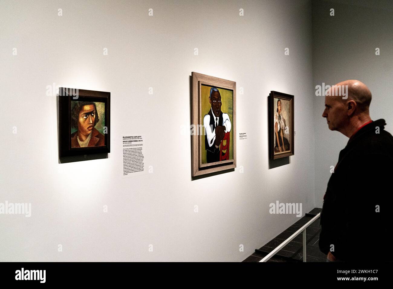 A visitor looking at paintings by William H. Johnson 'Man in a Vest' on view at upcoming Harlem Renaissance Exhibition at The Metropolitan Museum in New York during press preview on February 20, 2024 Stock Photo