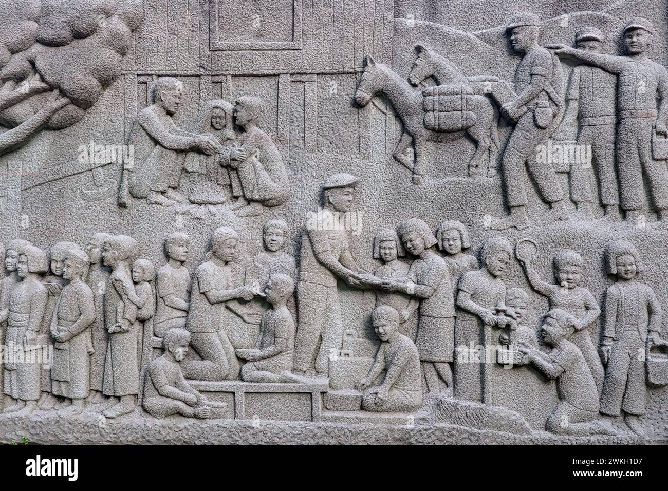 A frieze in Somdet Queen Mother Park in Bangkok, Thailand, depicting Thai soldiers giving assistance to Thai villagers Stock Photo