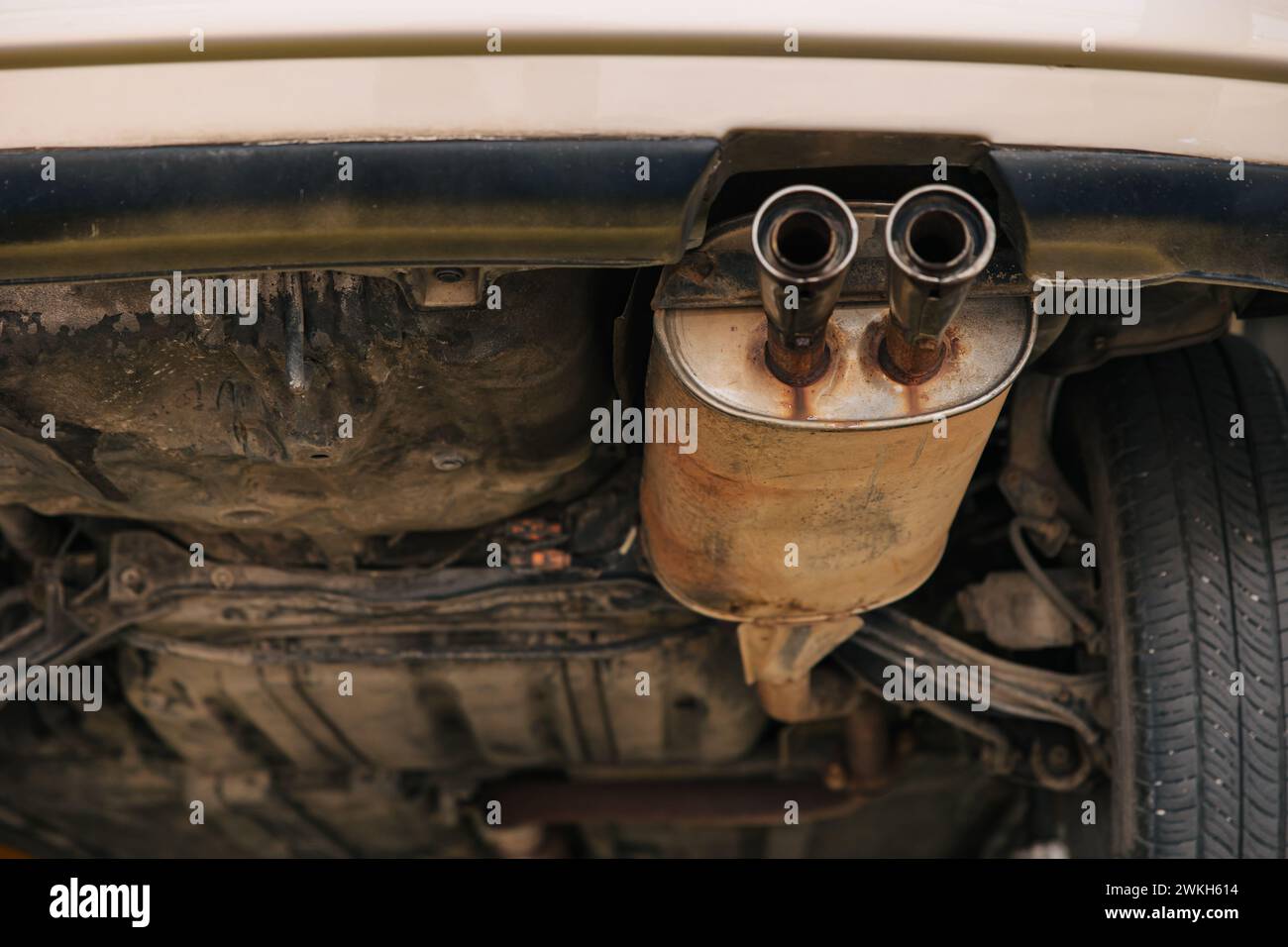 under car exhaust pipe muffler old aged rust rusty closeup auto part