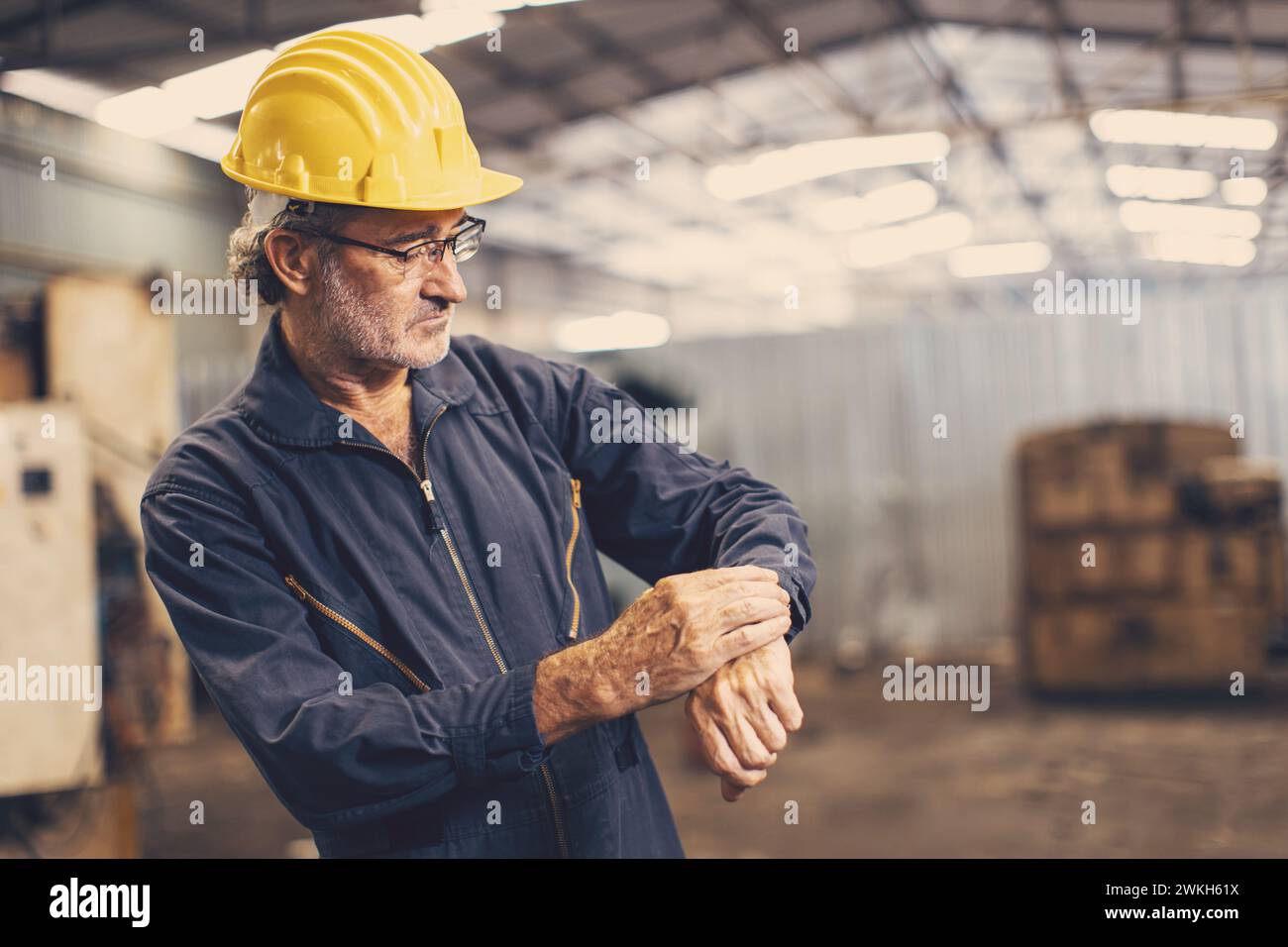senior worker engineer time check looking clock wrist for working in precise schedule times Stock Photo