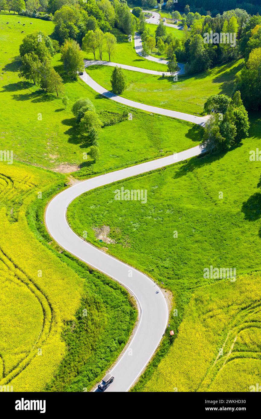 Luftbild der kurvenreichen Serpentinenstraße zwischen blühenden Rapsfeldern von Reifland nach Rauenstein, Pockau-Lengefeld, Erzgebirge, Sachsen, Deuts Stock Photo
