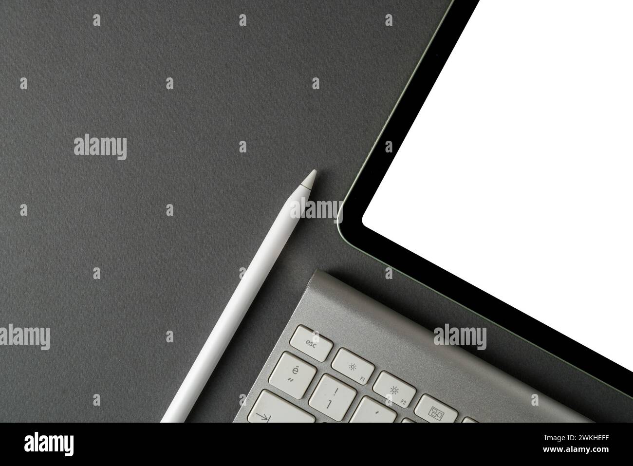 Tablet with blank screen, keyboard and stylus pen on dark gray background Stock Photo