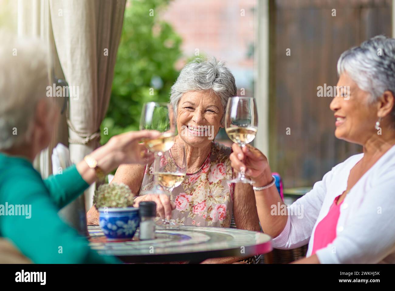 Lunch, wine and cheers with elderly friends in restaurant for bonding, date and relax. Retirement, hospitality and happiness with group of senior Stock Photo