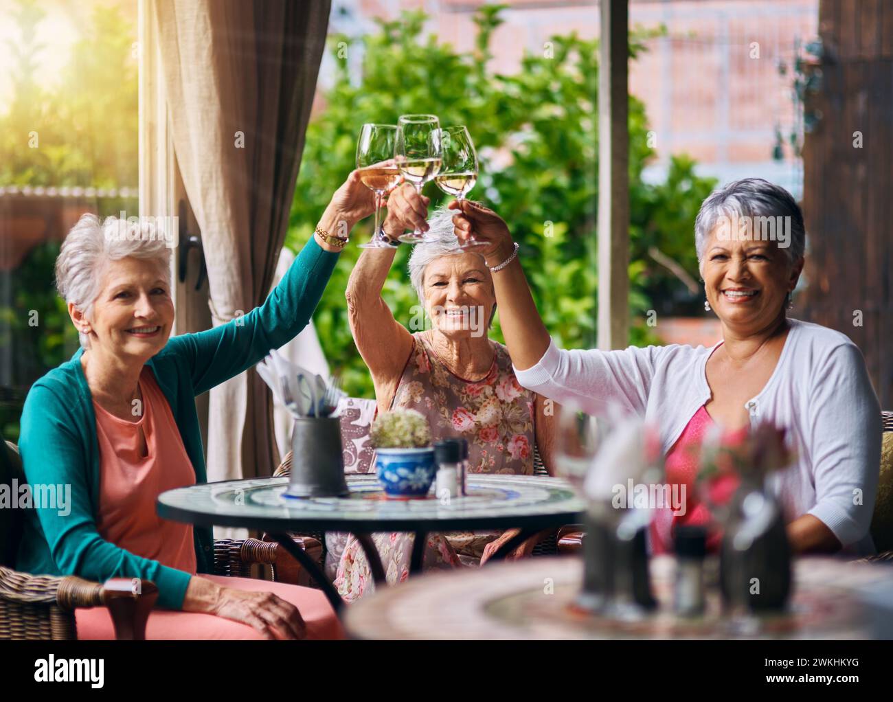 Cheers, wine and portrait with old women in restaurant for bonding, lunch and relax. Retirement, hospitality and happiness with senior friends with Stock Photo