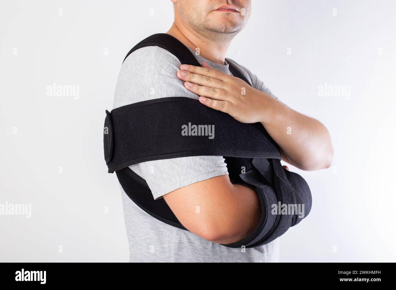 A man in a black bandage supporting the shoulder joint after ligament damage and bruise. Dislocation of the shoulder joint, fracture of the collarbone Stock Photo