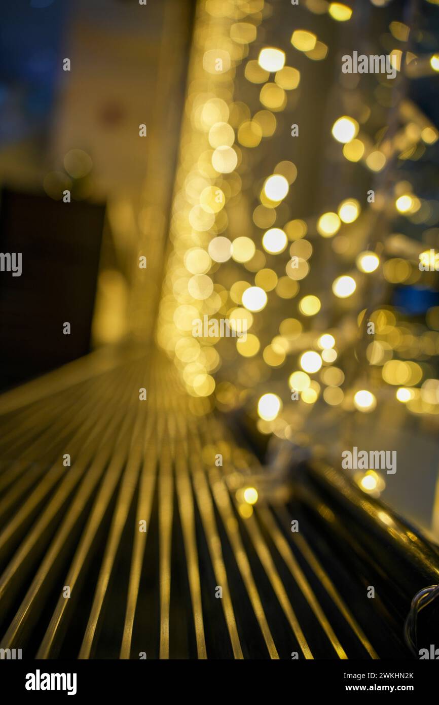 A black metal bench under white and gold lights Stock Photo - Alamy