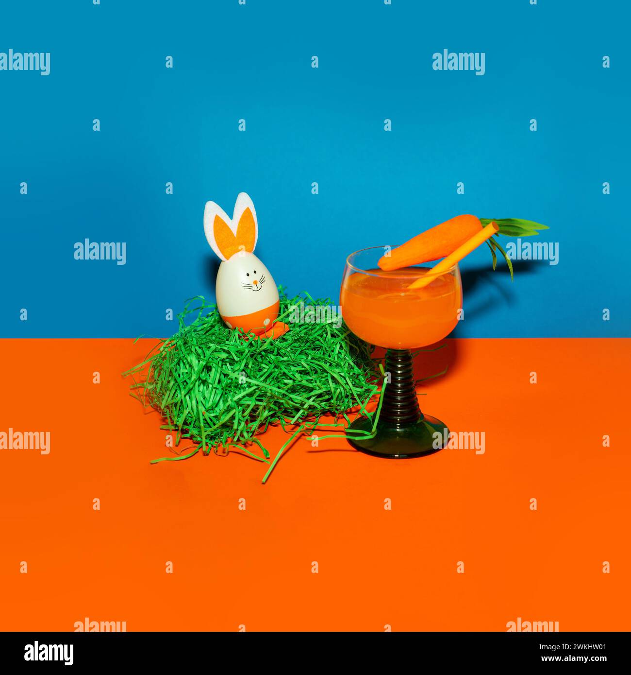 Easter egg and carrot in a glass on a colored background. Easter creative concept. Stock Photo