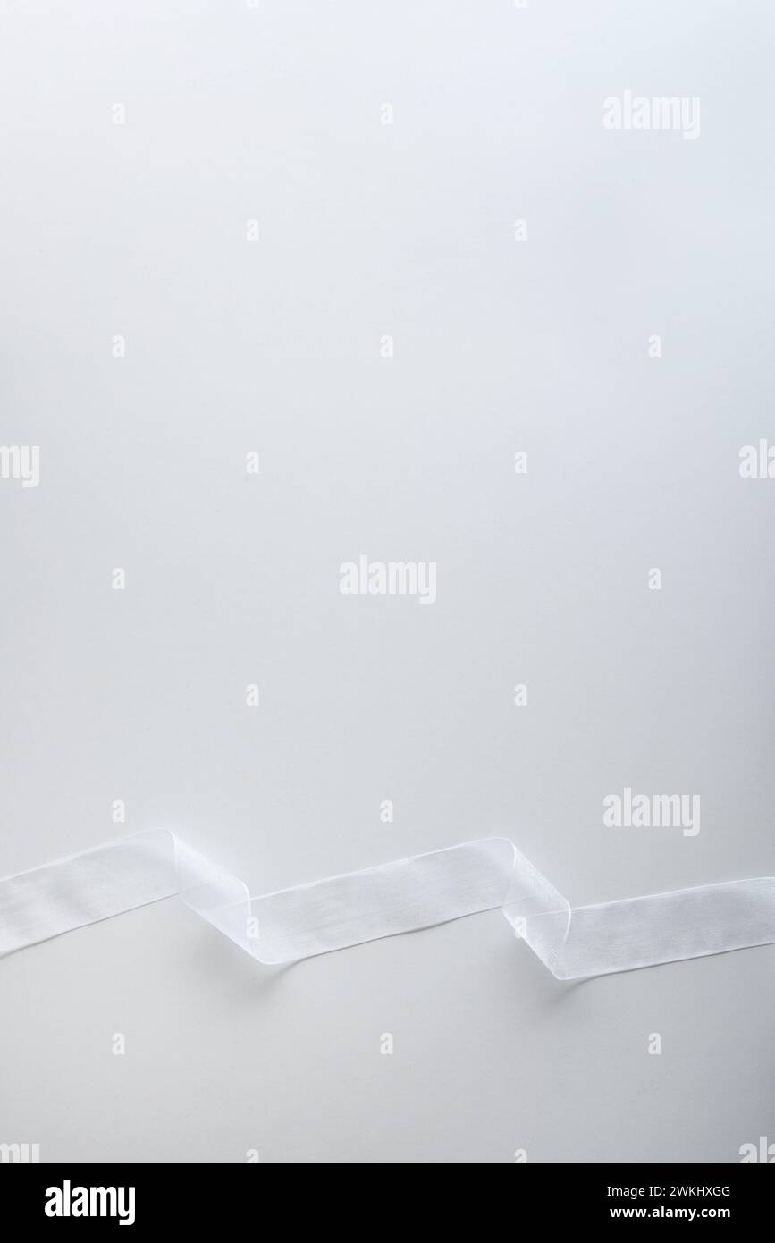 White tulle ribbon with waves on the bottom on white isolated ...