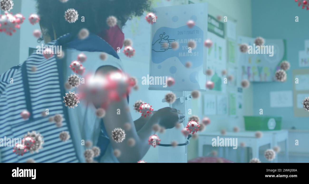 Multiple covid-19 cells floating against girl wearing face mask using hand sanitizer Stock Photo