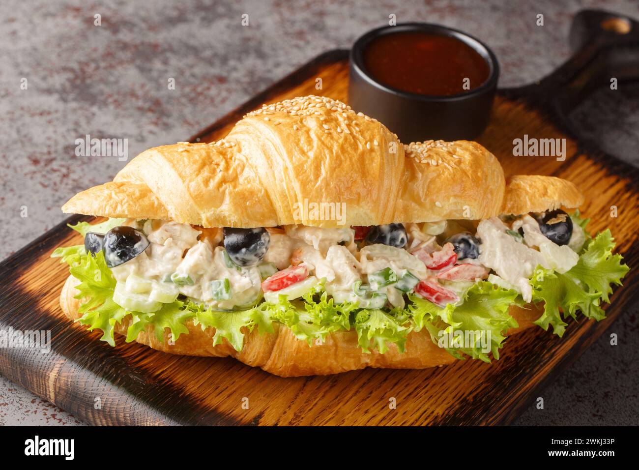 Homemade Healthy Chicken Salad Croissant Sandwich closeup on a wooden board on the table. Horizontal Stock Photo
