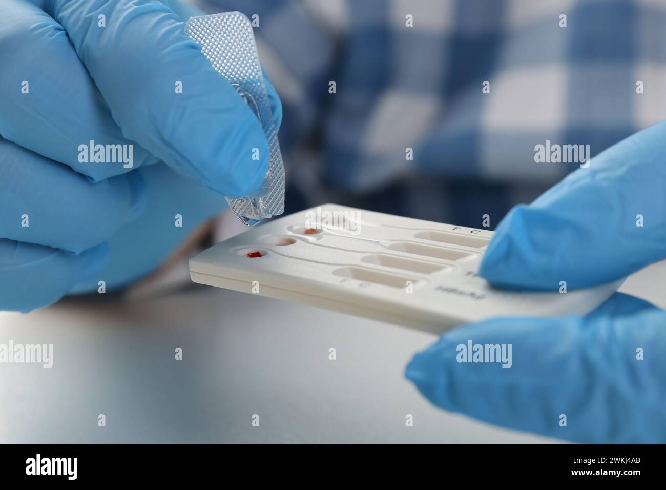 Doctor dropping buffer solution onto disposable multi-infection express ...