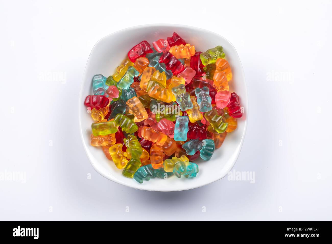 Sweet Delights: Colorful Gummibears in Special Assorted Flavors & Colors in White Bowl. Top View on White Background. Stock Photo