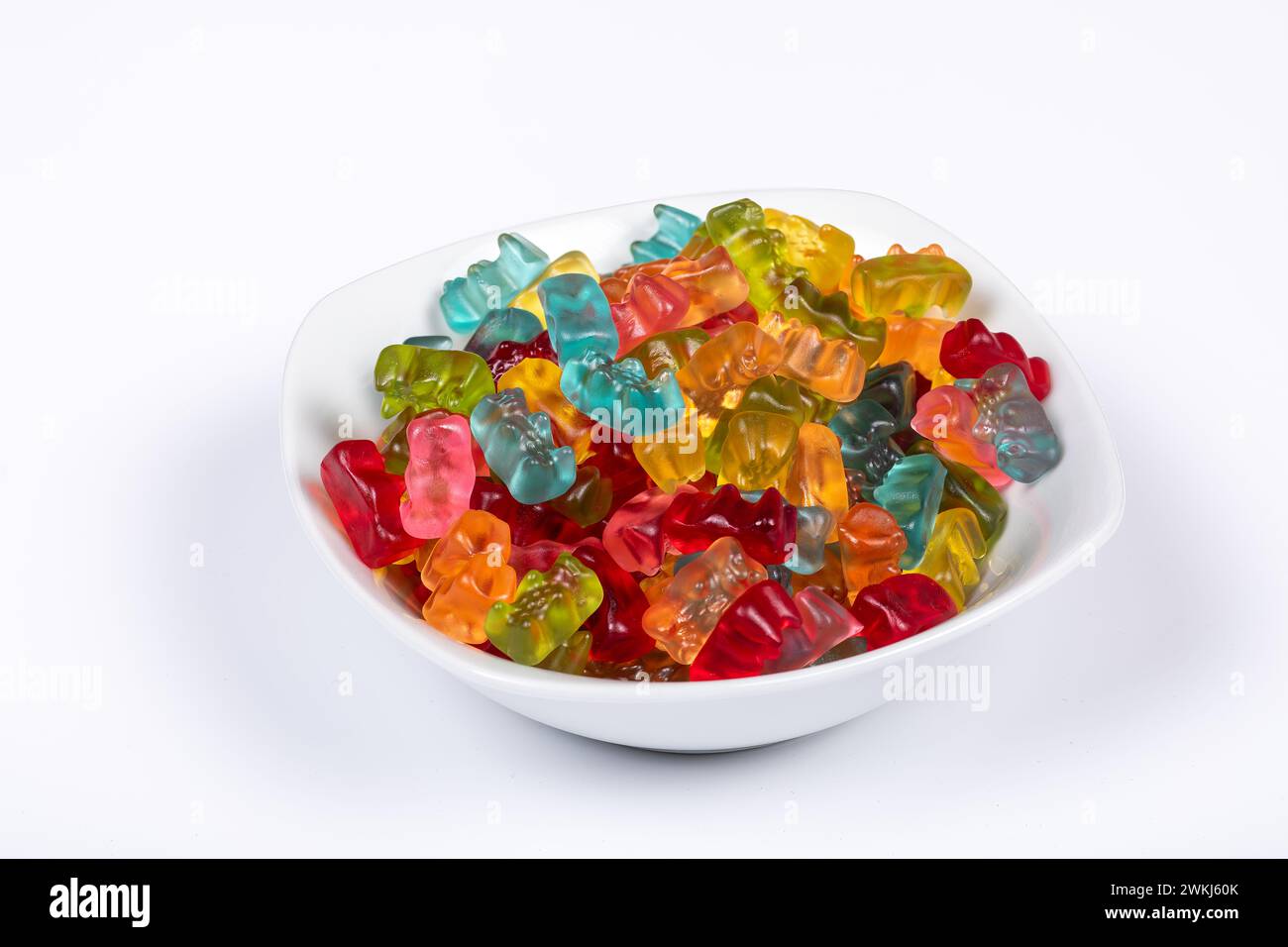 Colorful Gummibears Assorted Flavors in White Bowl on White Background. Side View. Stock Photo