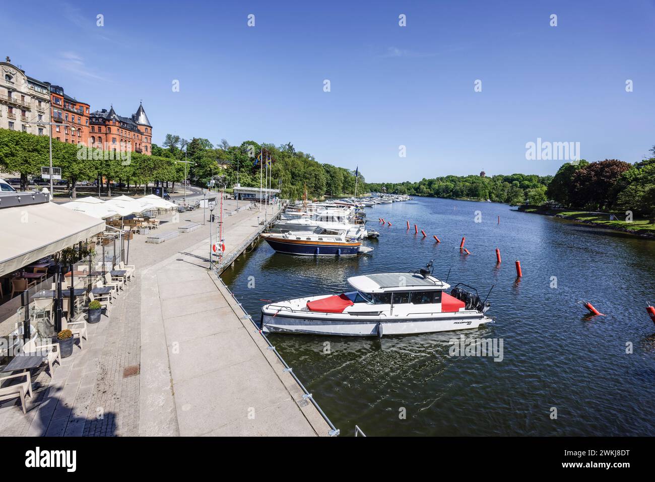 Boats moored by the Strandvägen quay promenade on historic treelined ...