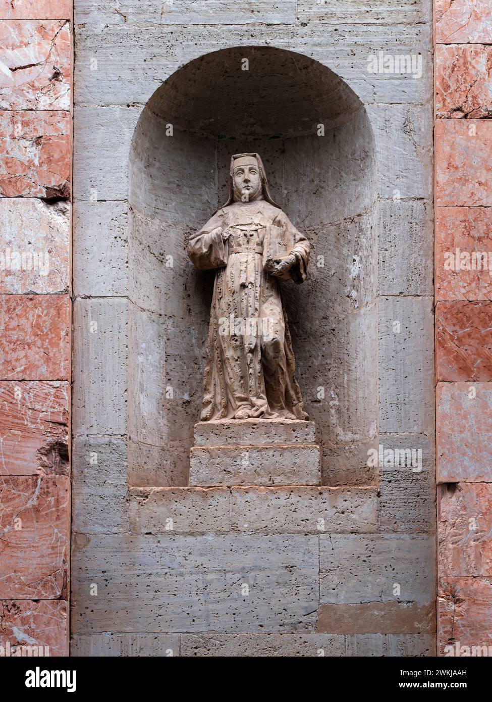 The small statue of a nun shows the scars from a past conflict in Orihuela, Alicante, Spain. Stock Photo