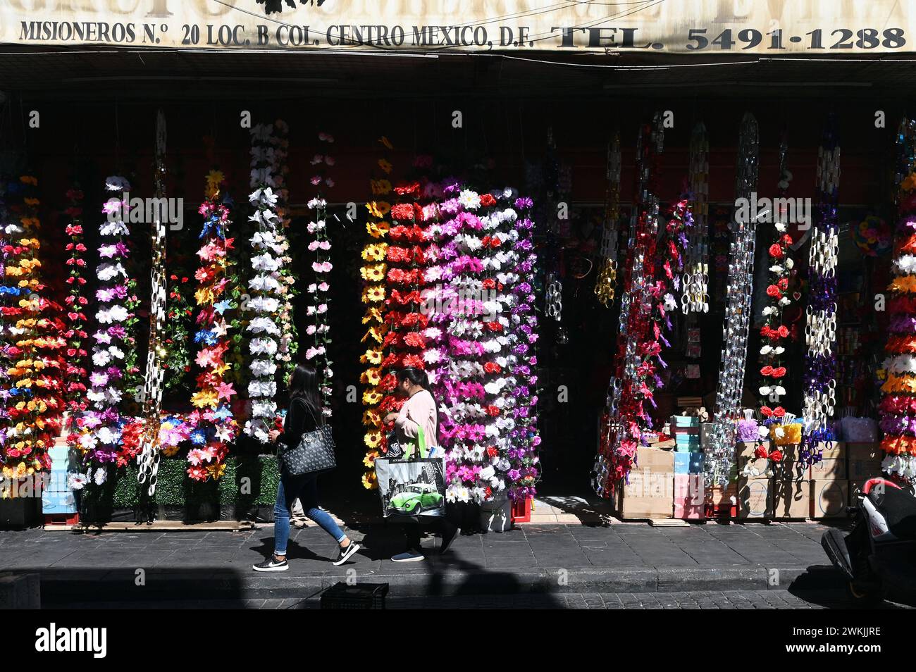 Passers-by in front of an artificial flower shop in the historic centre, Mexico City Stock Photo