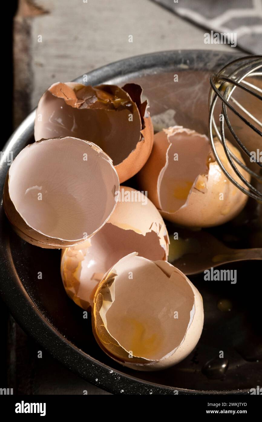 Cracked eggshells and whisk on the table, space for text Stock Photo