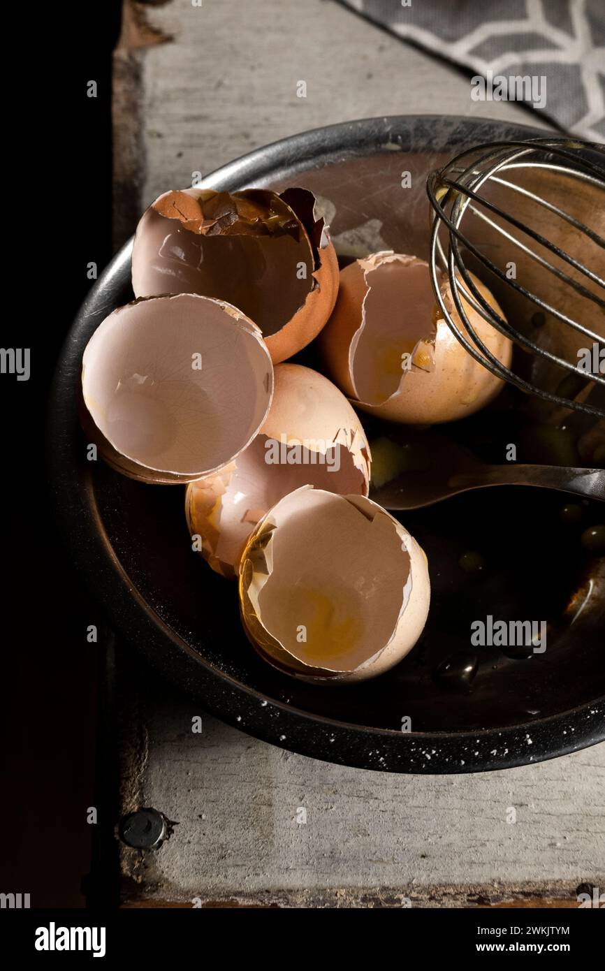 Cracked eggshells and whisk on the table, space for text Stock Photo