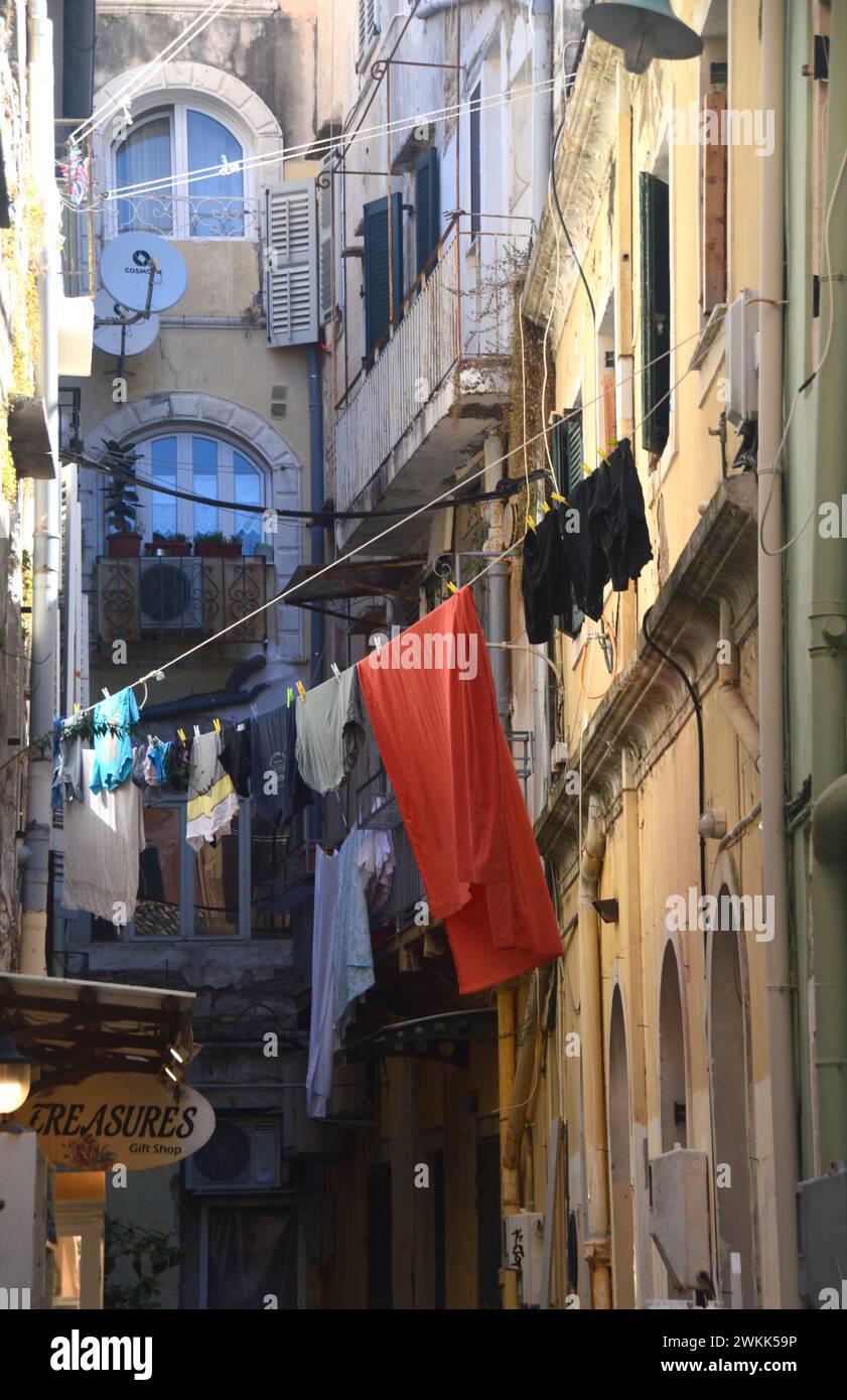 Washing Hanging on Clothes Line Outside in the Narrow Street Between Buildings and Above Shops in the Old Town of Corfu, Greece, EU. Stock Photo