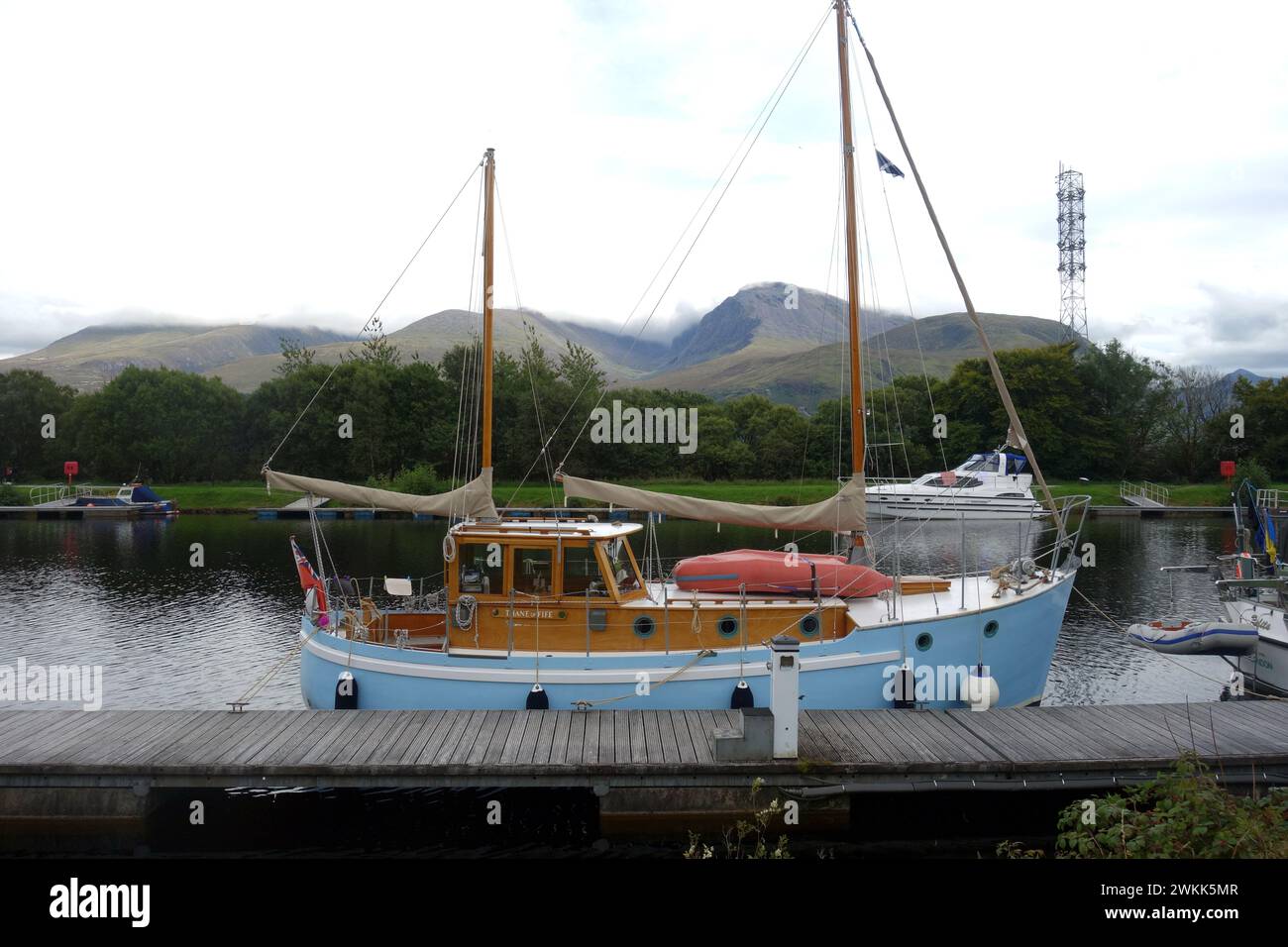 Pleasure Boat Moored on Tow Path on the Caledonian Canal with Ben Nevis by 'Neptunes Staircase' near Fort William in the Highlands of Scotland. Stock Photo