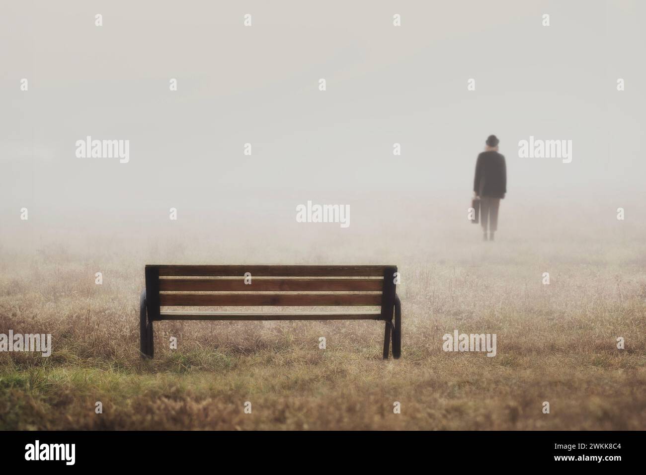 bench abandoned by a blurry person who in the background has left on his journey Stock Photo