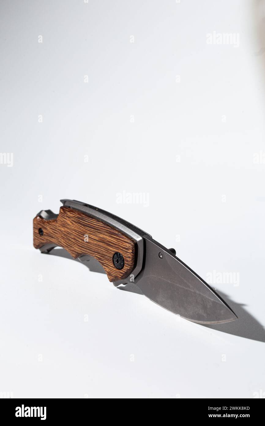 High-quality image featuring a stylish modern pocket knife with a durable wood handle, perfect for outdoor activities. Stock Photo