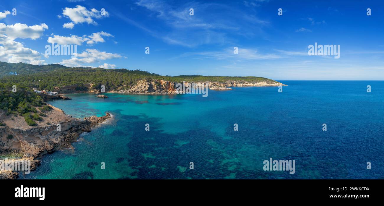 aerial view the green and rugged hilly coast of northern Ibiza with the turquoise waters of Cala Xarraca bay Stock Photo
