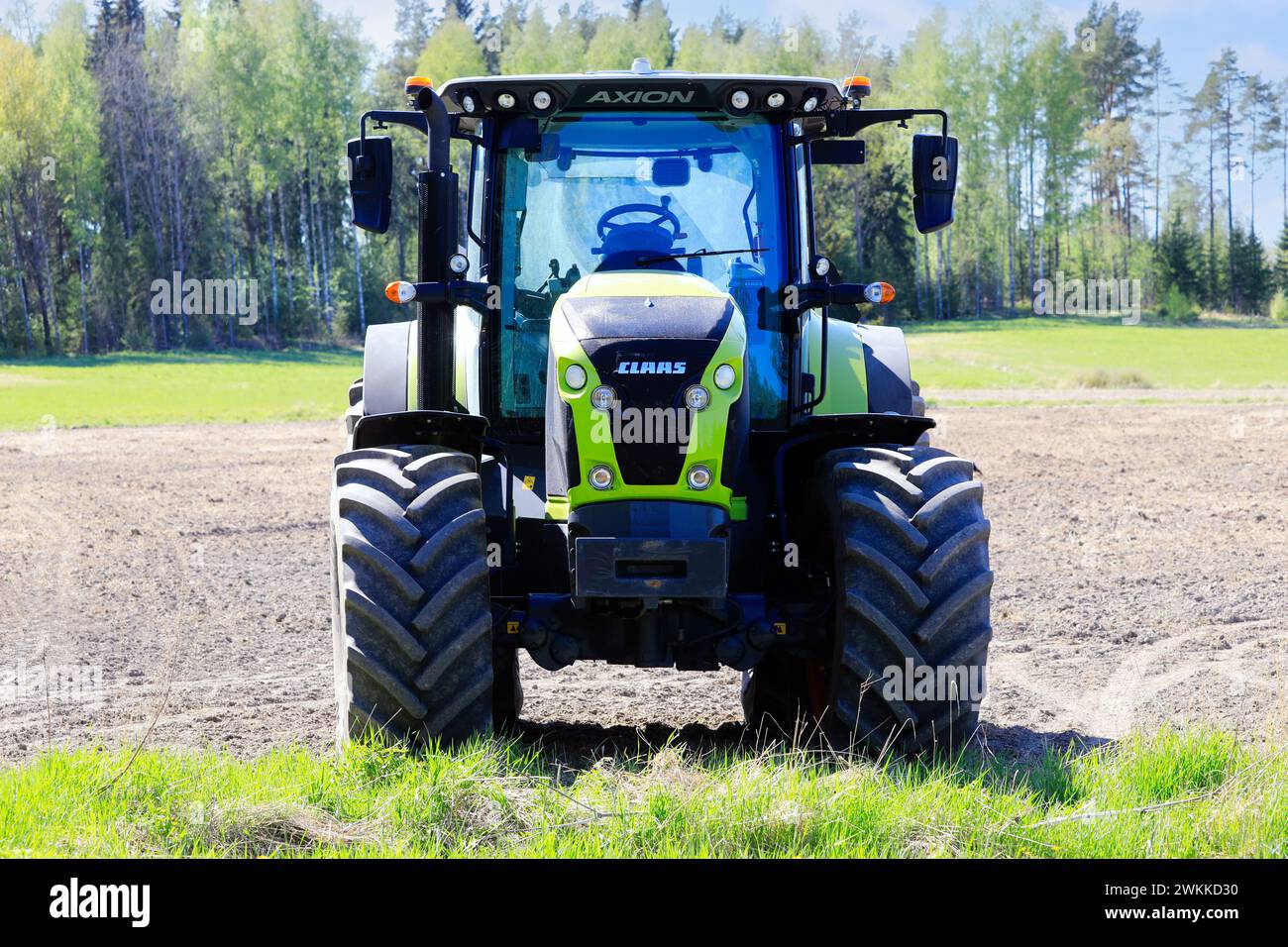 Claas Axion 850 tractor in field on a sunny day of spring, front view. Salo, Finland. May 20, 2023. Stock Photo